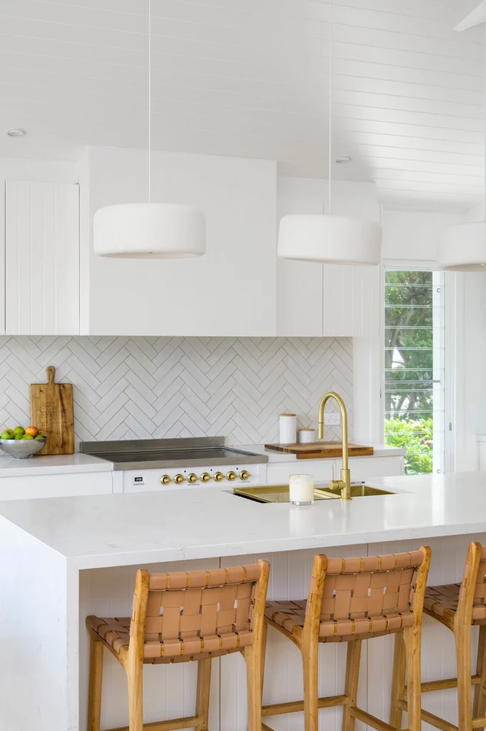 white kitchen with island bench and timber and gold accents